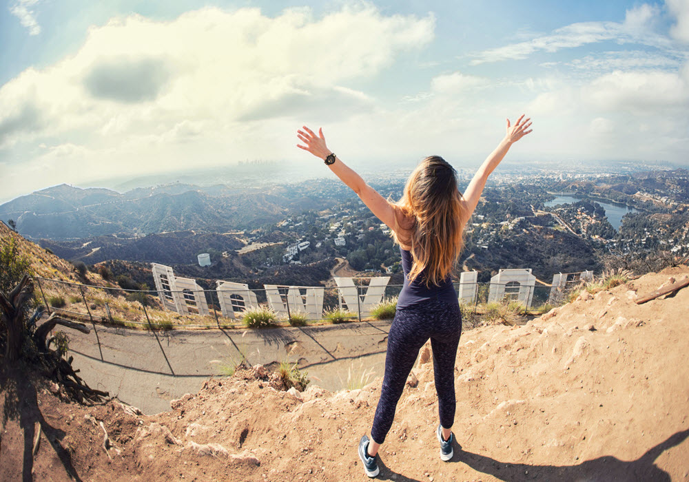 Woman at the top of the Hollywood sign in Los Angeles, California.