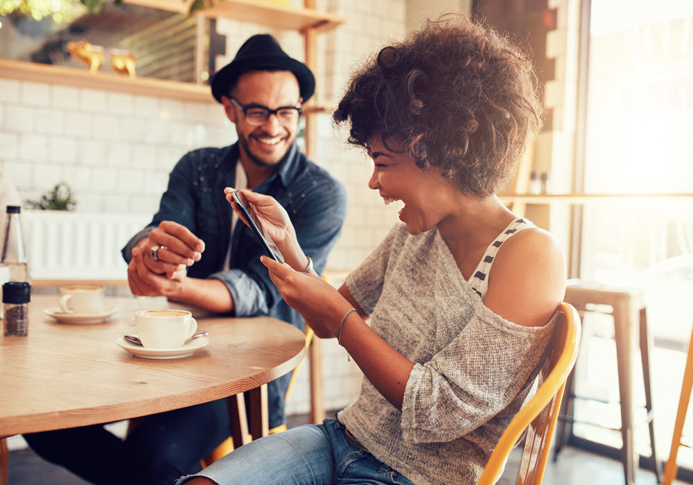 Smiling woman and man at a cafe.