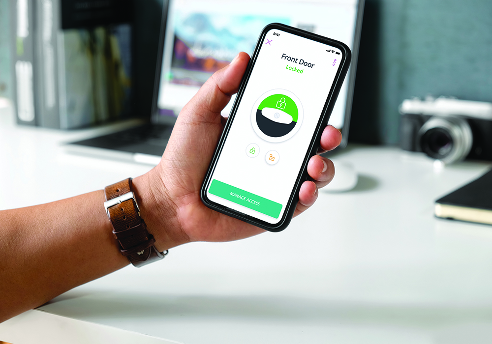 Person holding a phone and using an application that says "front door locked"