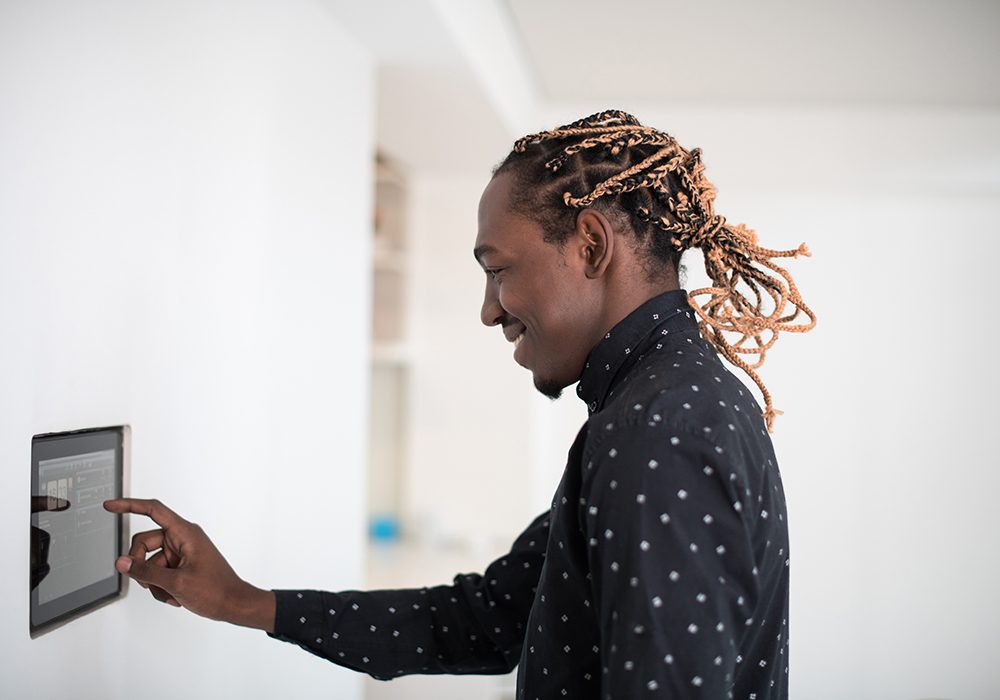 Happy resident adjusting thermostat in his apartment