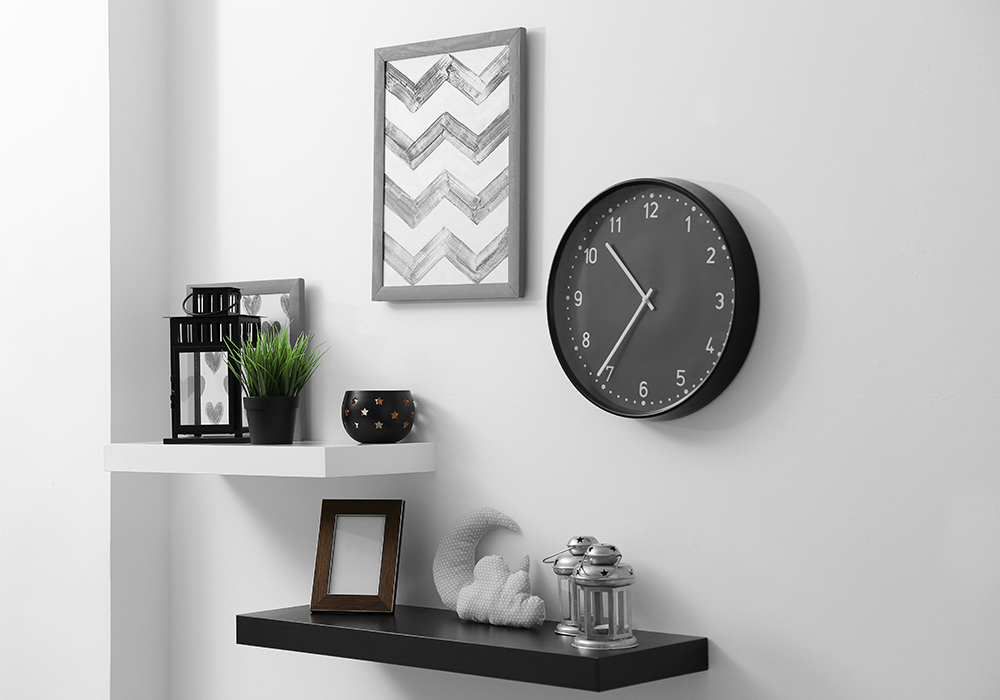 Apartment wall decorated with shelving, a clock, and a framed picture