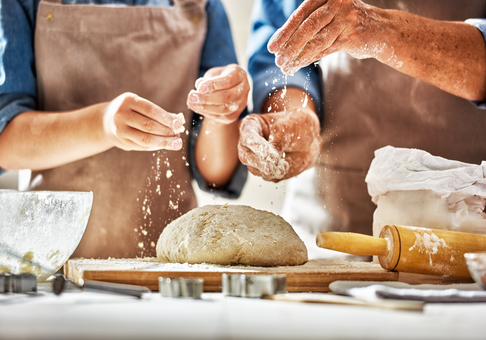 Man and woman learns to bake bread as a new hobby in their apartment home.