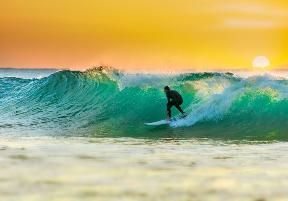 Man surfing at sunrise