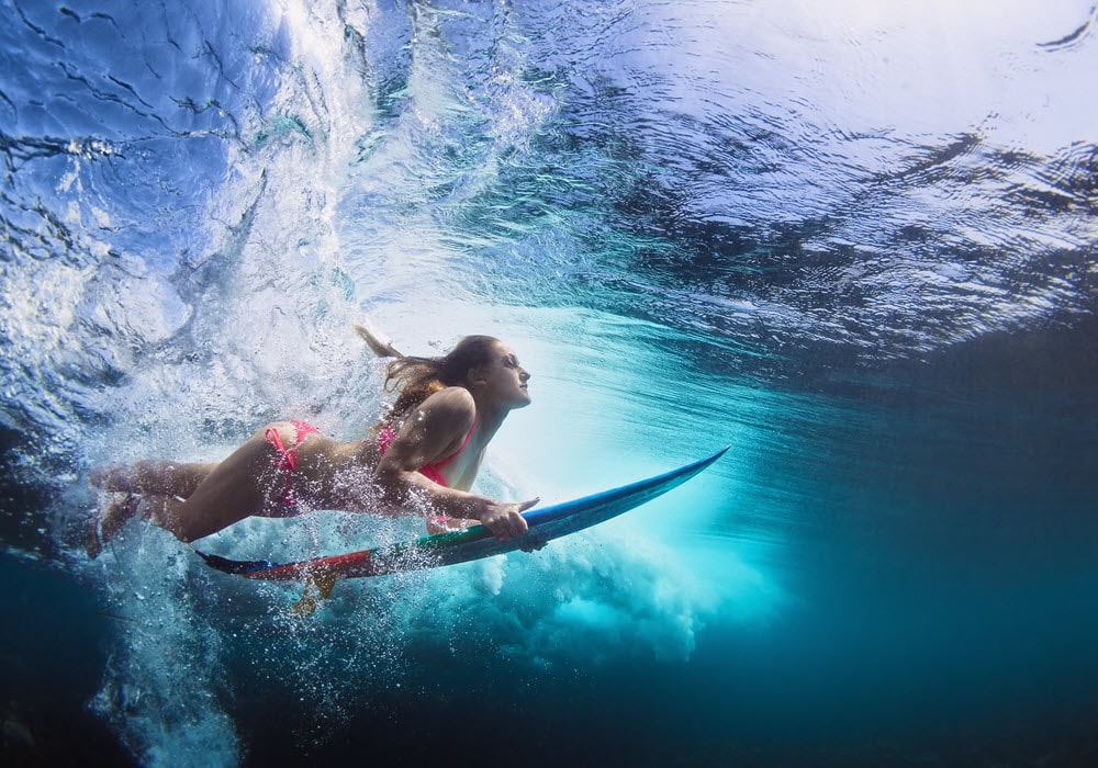 Woman surfing the waves with her surf board 