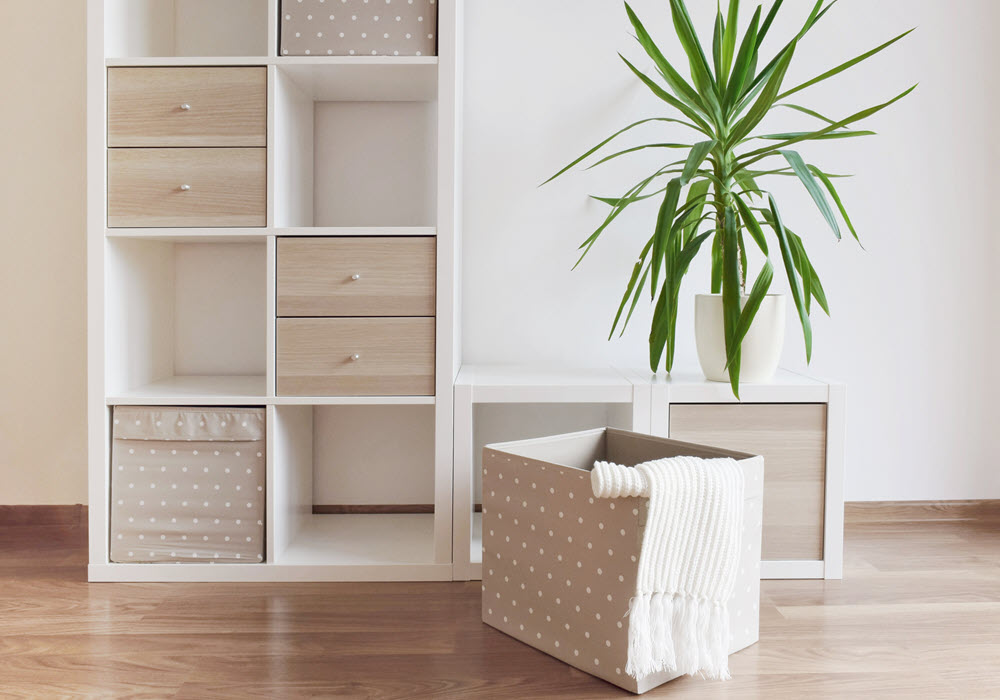 White shelves with decorative storage boxes in an apartment.