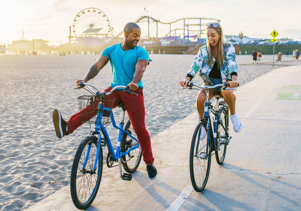 Two friends bicycling at the beach in Santa Monica.