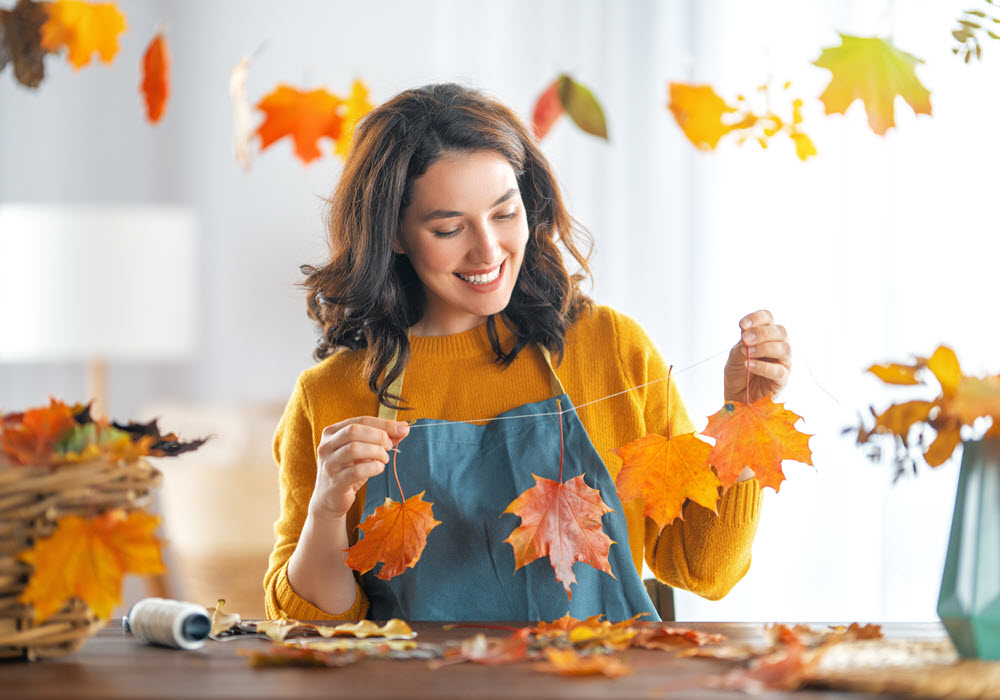 Woman creating fall leaves decor.