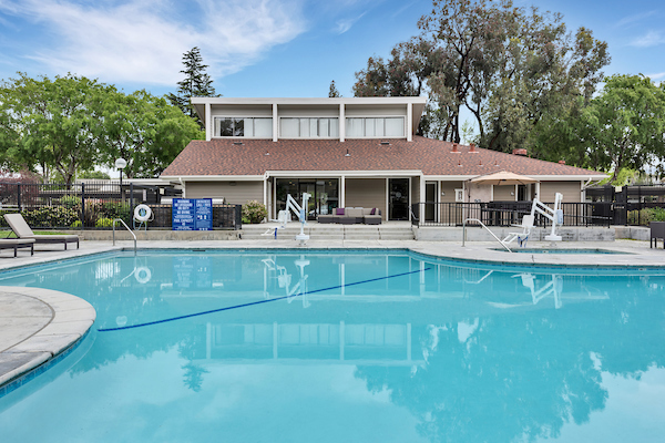 Outdoor swimming pool and spa surrounded by lounge chairs.