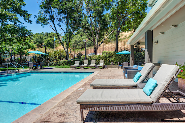 Outdoor swimming pool surrounded by lounge chairs.