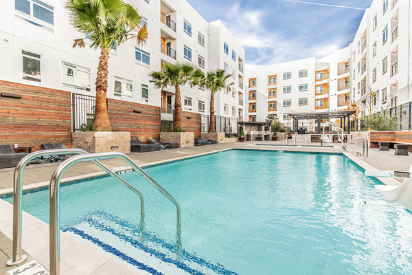 Outdoor swimming pool area surrounded with lounge seating.