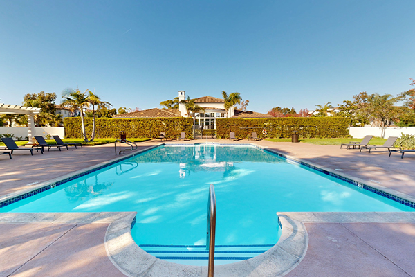 Outdoor swimming pool surrounded by lounge chairs.